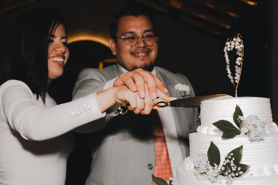 Pareja partiendo el pastel de bodas