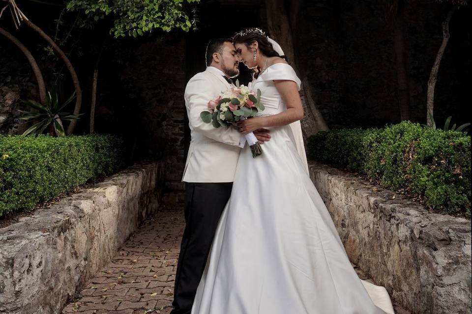 Novios posando en medio del camino