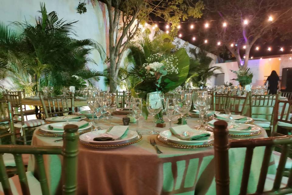 Mesa adornada con vajilla blanca y arreglo floral