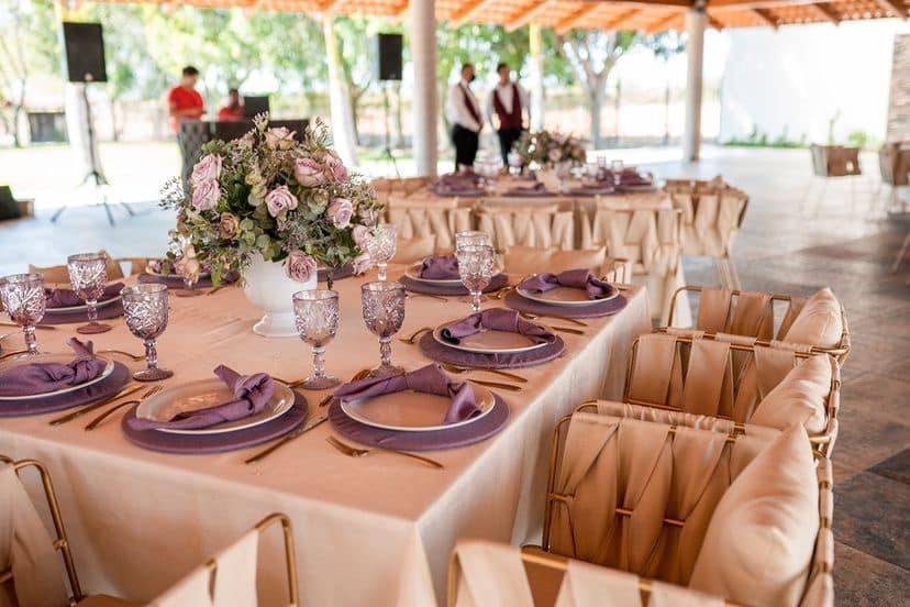 Mesa decorada con vajilla blanca y lila