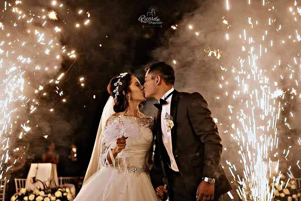 Novios besándose y detrás chisperos