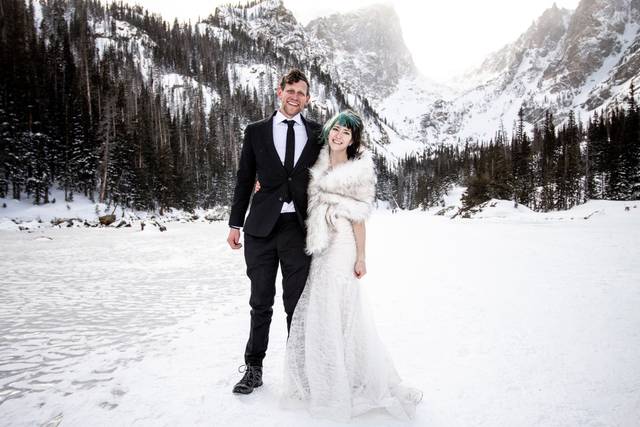 Novios abrazados en medio de las montañas nevadas