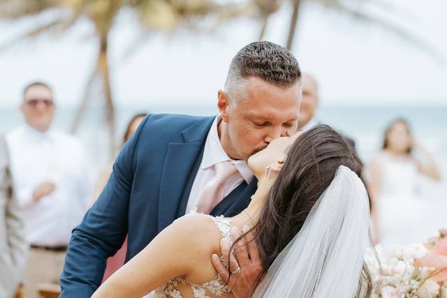 Novios besándose frente a sus invitados