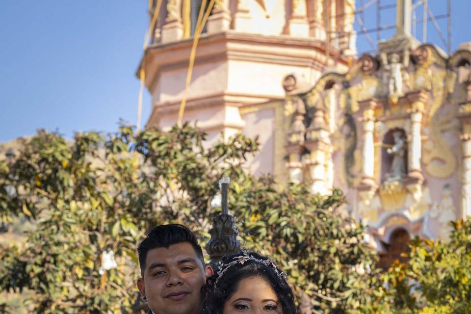 Novios posando frente a la iglesia
