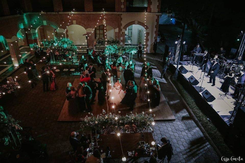 Evento de noche iluminado con luces cálidas y grupo musical