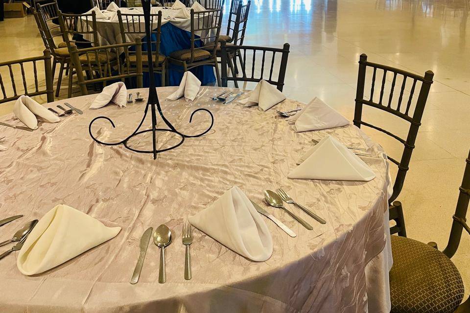 Mesa con mantel blanco y florero alto