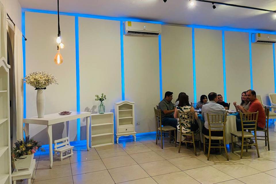 Salón con una mesa redonda e invitados
