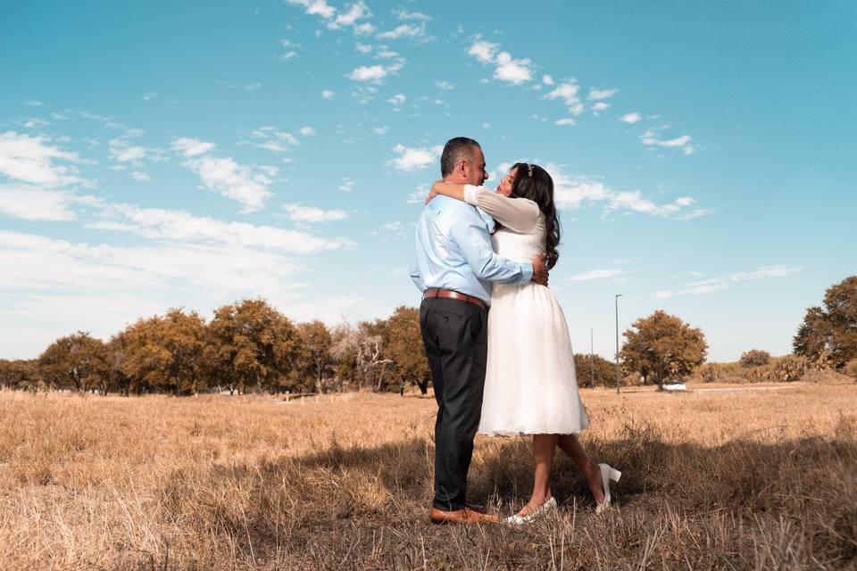 Novios abrazados en medio del campo