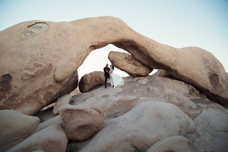 Novios posando sobre rocas gigantes