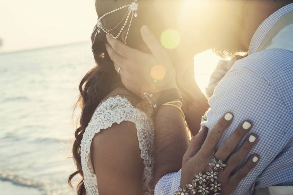 Novios besándose frente al mar en el atardecer