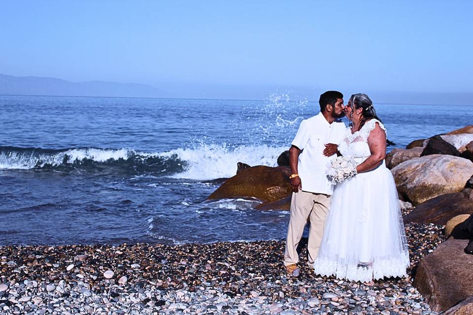 Pareja dándose un beso en la playa