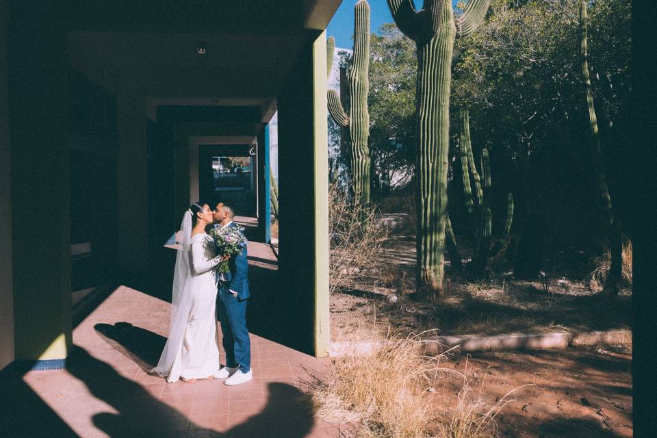 Pareja dándose un beso cubiertos del sol