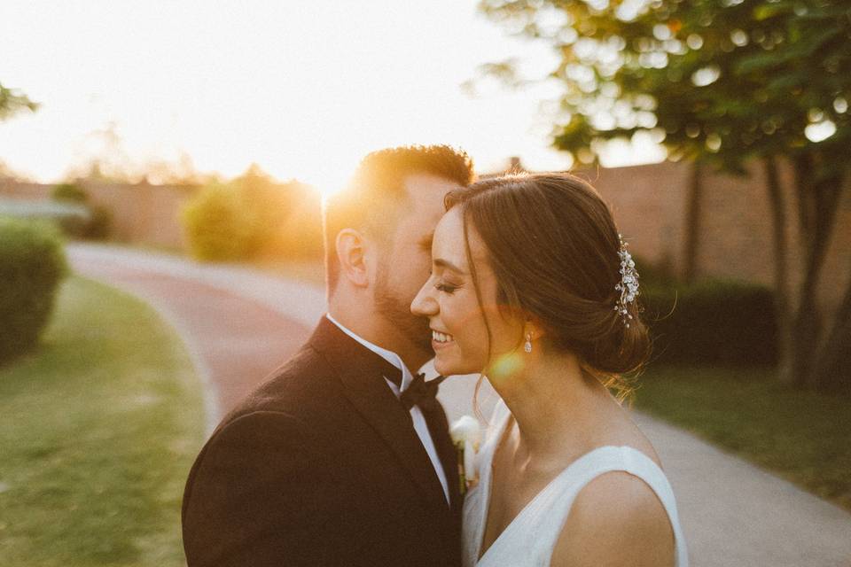 Novio dándole un beso a la novia al atardecer