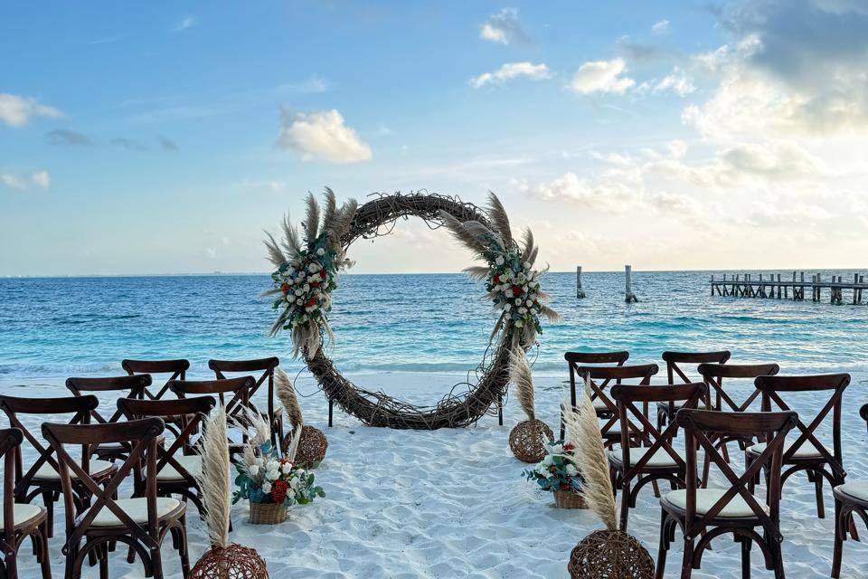 Sillas y arco de flores en la playa