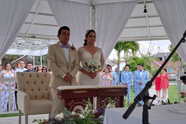 Novios casándose bajo una carpa blanca