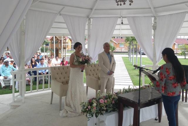 Novios parados frente a la oficiante de ceremonias