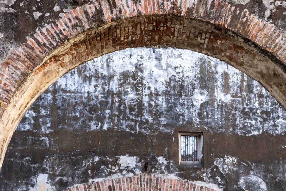 Pareja de espaldas caminando por un patio en ruinas