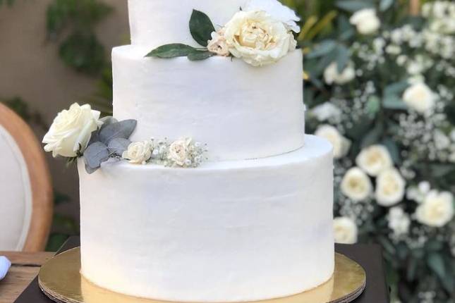 Pastel de tres pisos blanco con rosas