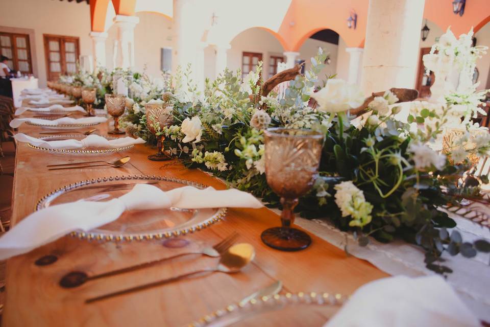 Platos de cristal en la mesa con arreglo floral