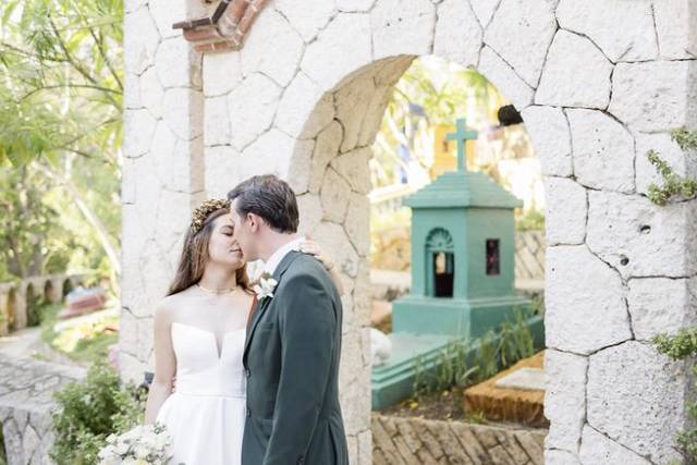 Recién casados frente a un arco de piedra