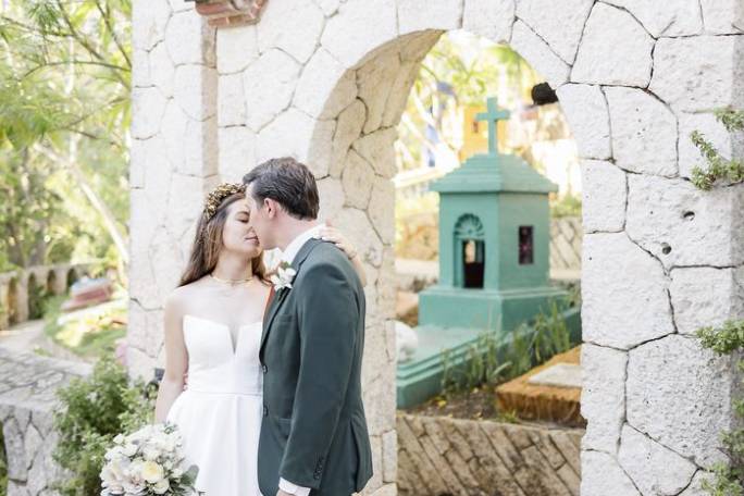 Recién casados frente a un arco de piedra