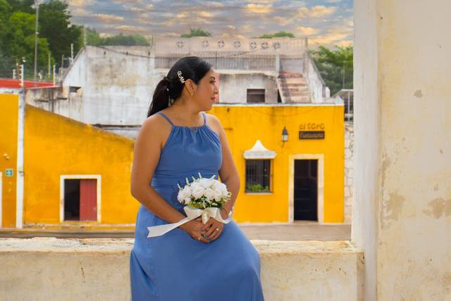 Mujer de vestido azul con un ramo blanco