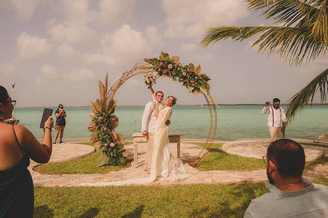 Novios posando en un arco de flores