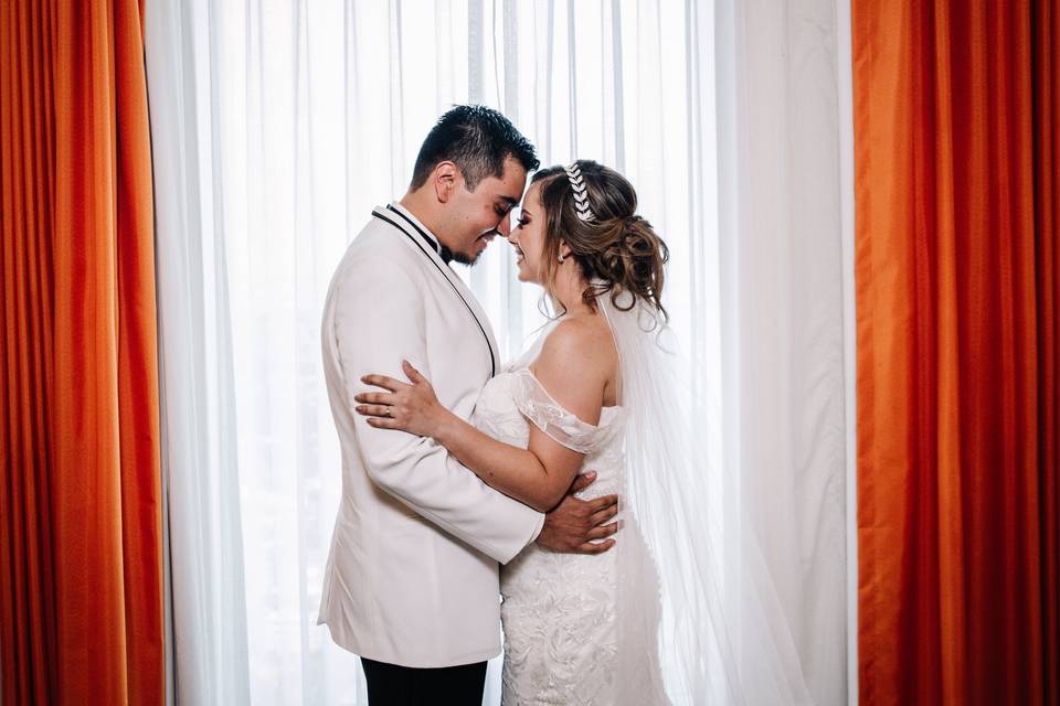 Novios abrazados frente a la ventana