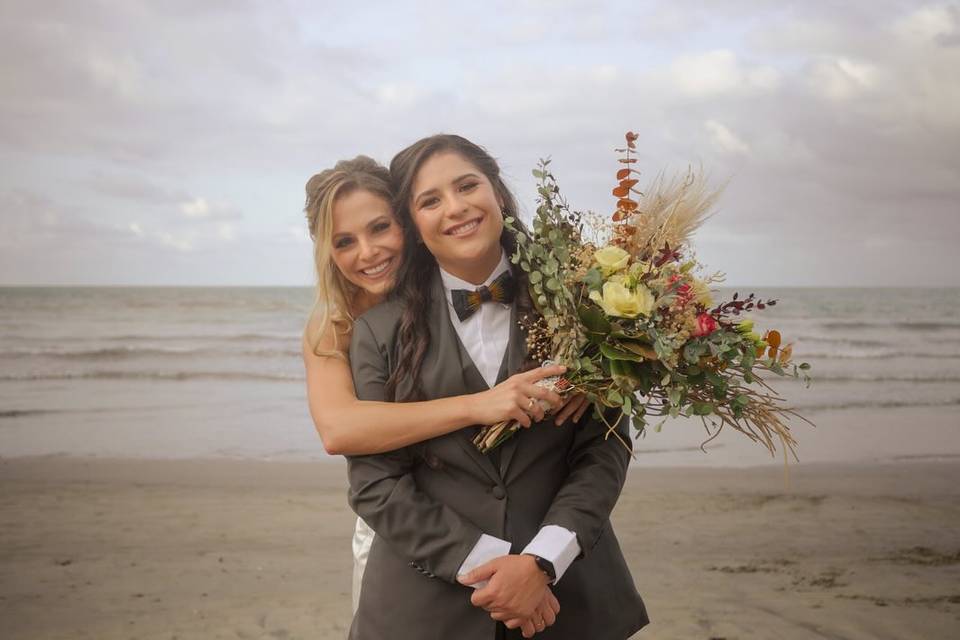 Novias abrazadas frente al mar