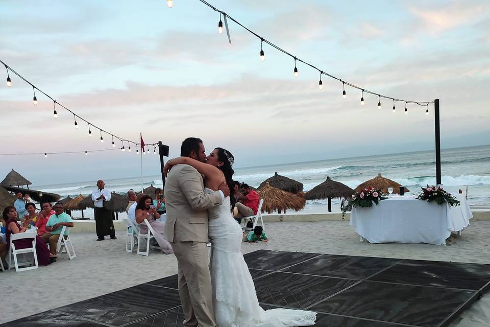 Recién casados bailando en la pista de baile en la playa