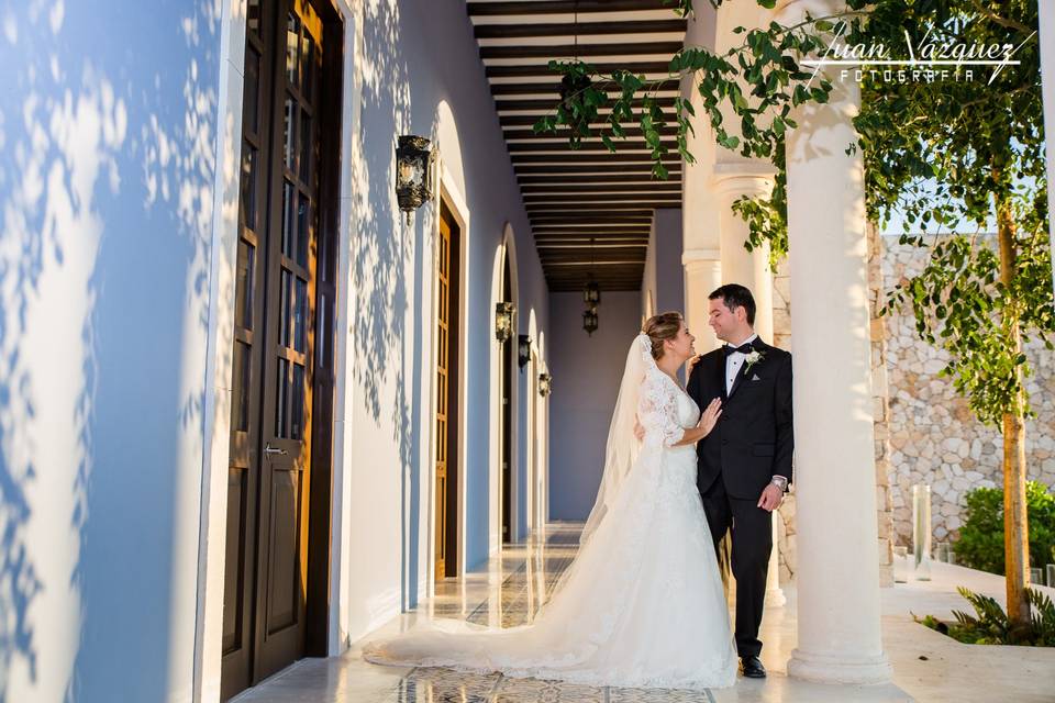 Novios recargados en una columna blanca