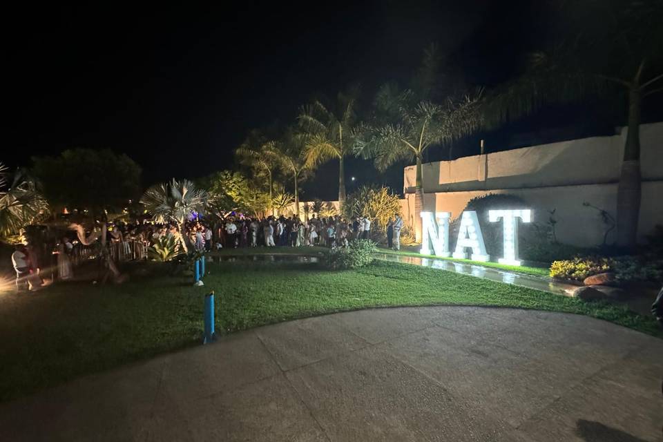 Jardín de noche con letras gigantes blancas