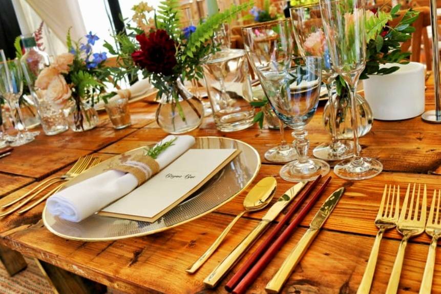 Cubiertos dorados con platos y copas de cristal