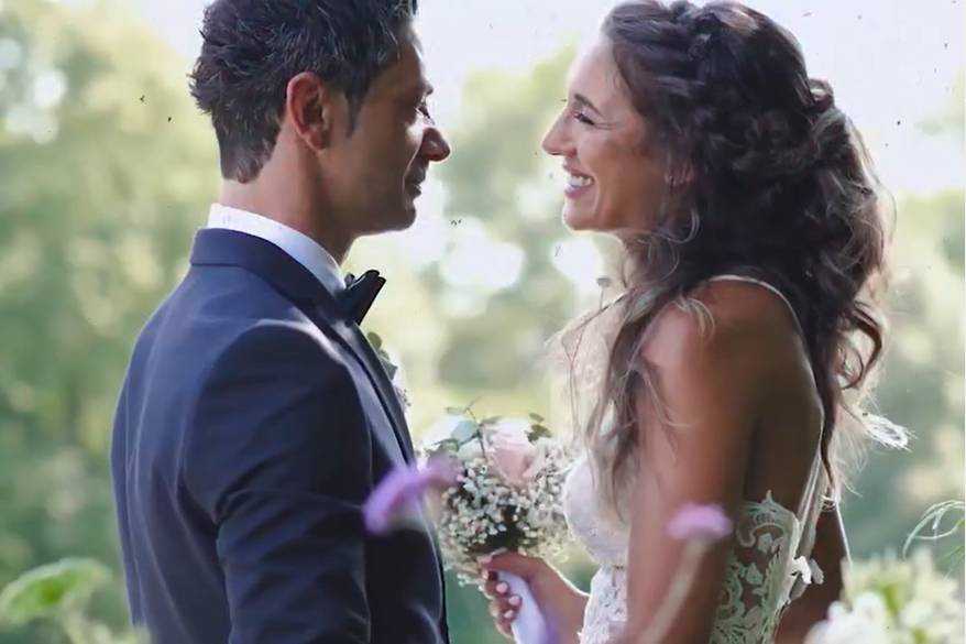 Pareja sonriéndose el uno al otro en un campo de flores