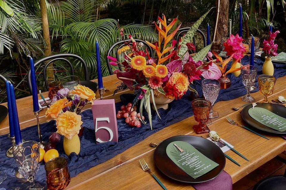 Mesa de madera decorada con velas y flors de colores