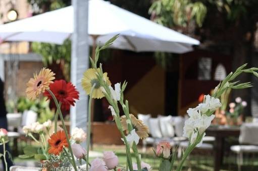 Mesa con copas verdes y jarros de barro con flores