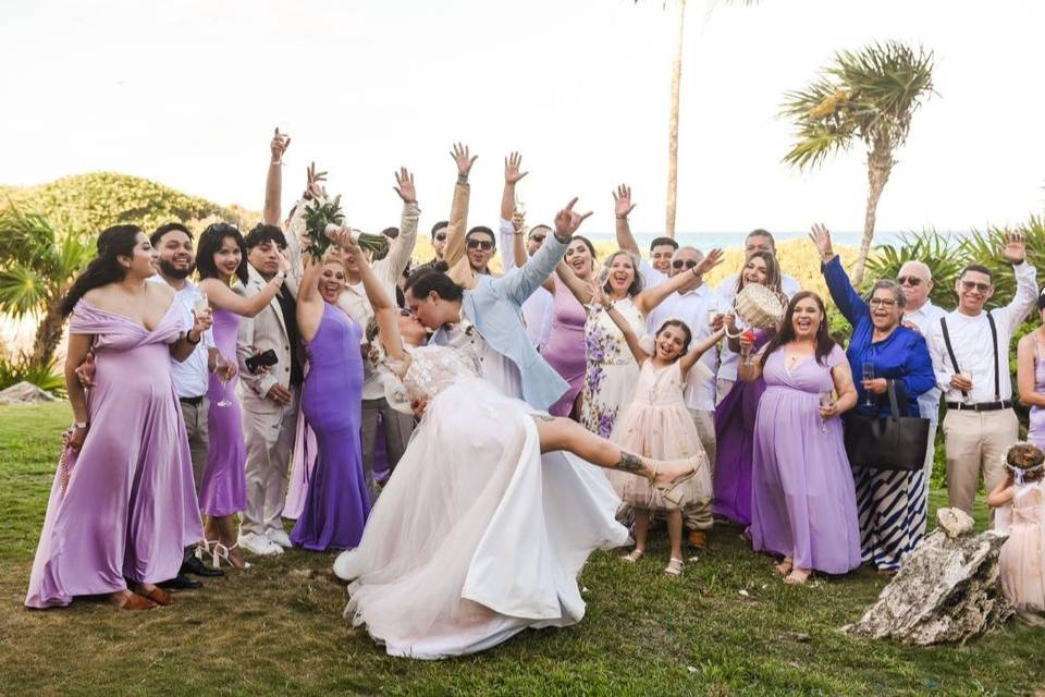 Novios dándose un beso frente a sus invitados