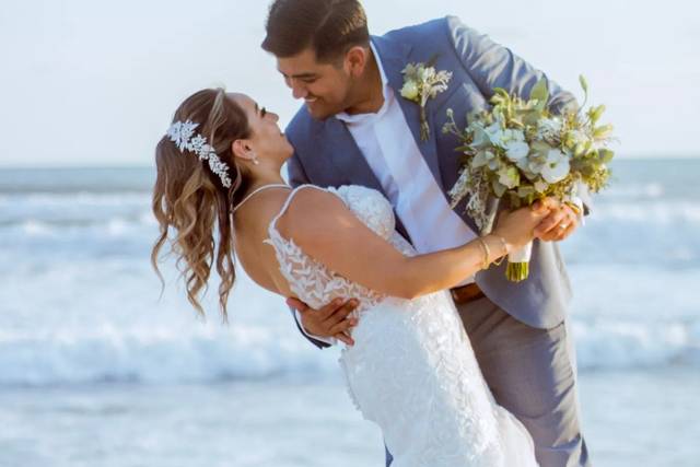 Novio abrazando a la novia frente a la playa