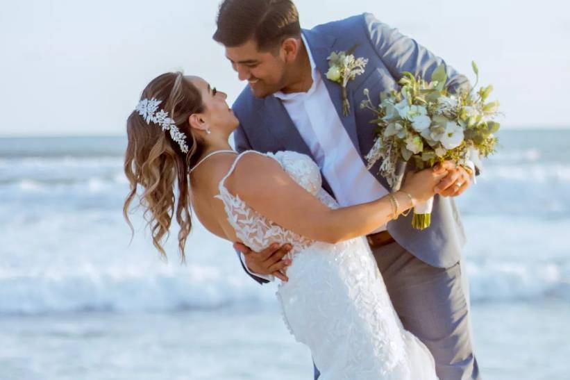 Novio abrazando a la novia frente a la playa