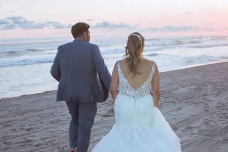 Recién casados caminando por la playa