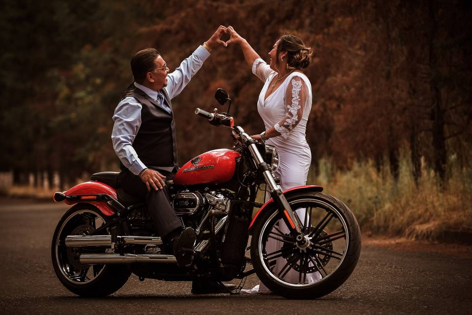 Novios posando en una moto roja