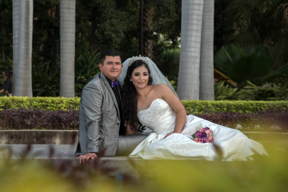 Novios sentados en el jardín posando