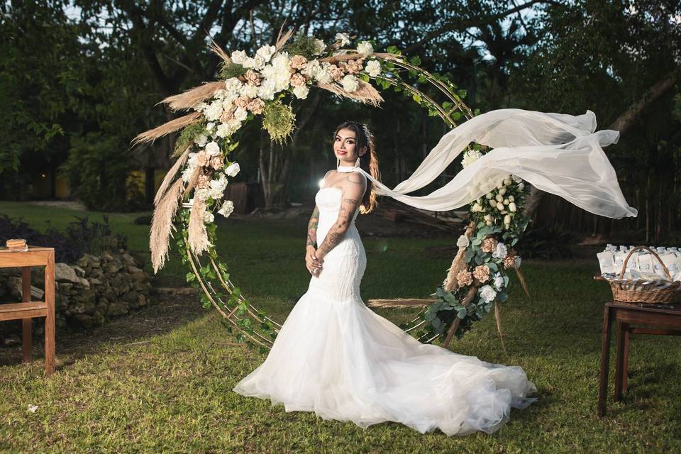 Novia posando frente un arco de flores