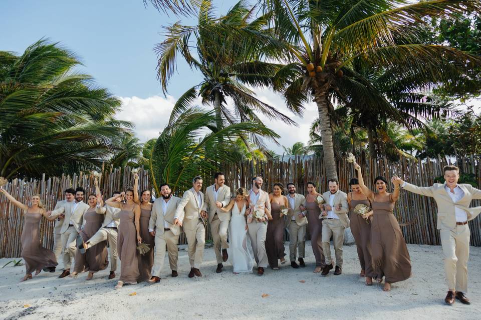 Novios con sus damas de honor y bestman en la playa