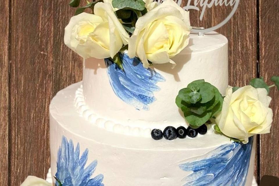 pastel blanco con rosas y manchas azules