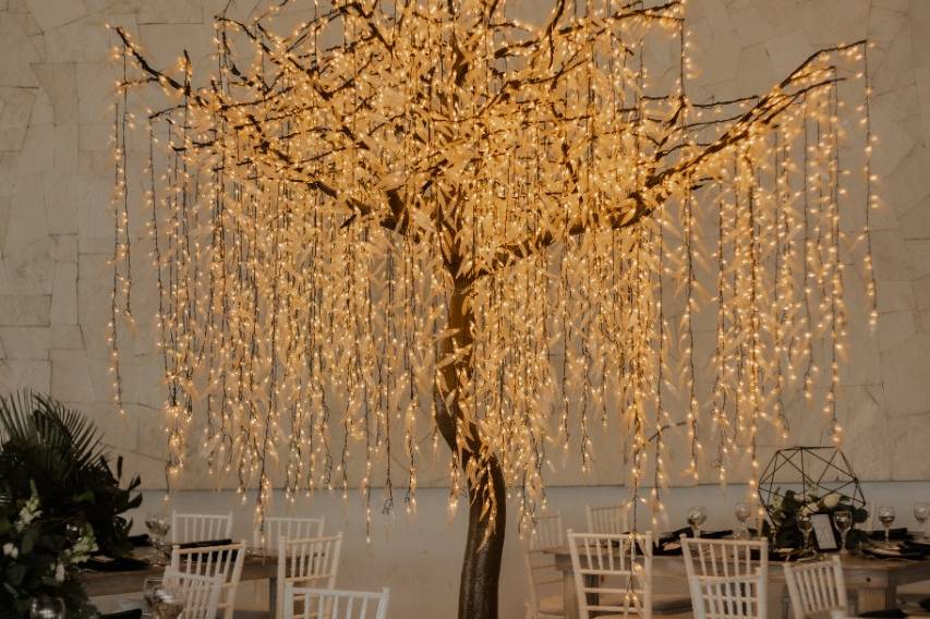 Sillas y mesas con un árbol de luces