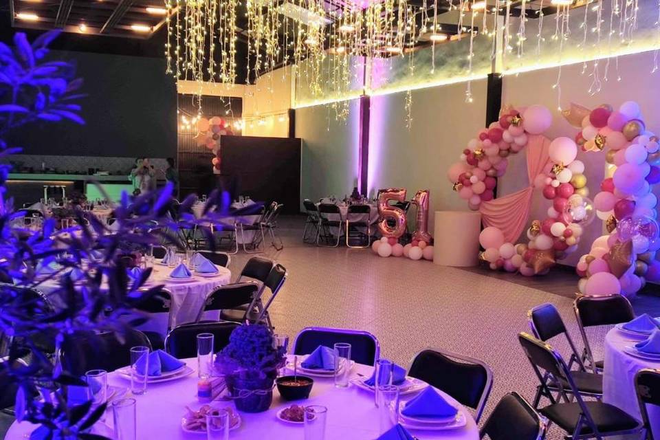 Salón decorado con globos rosas y luces azules