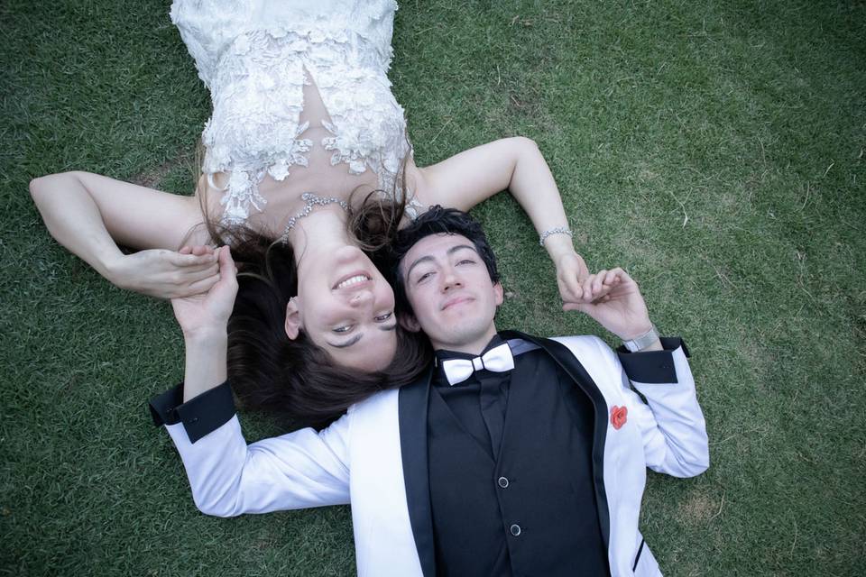 Novios tirados en el pasto