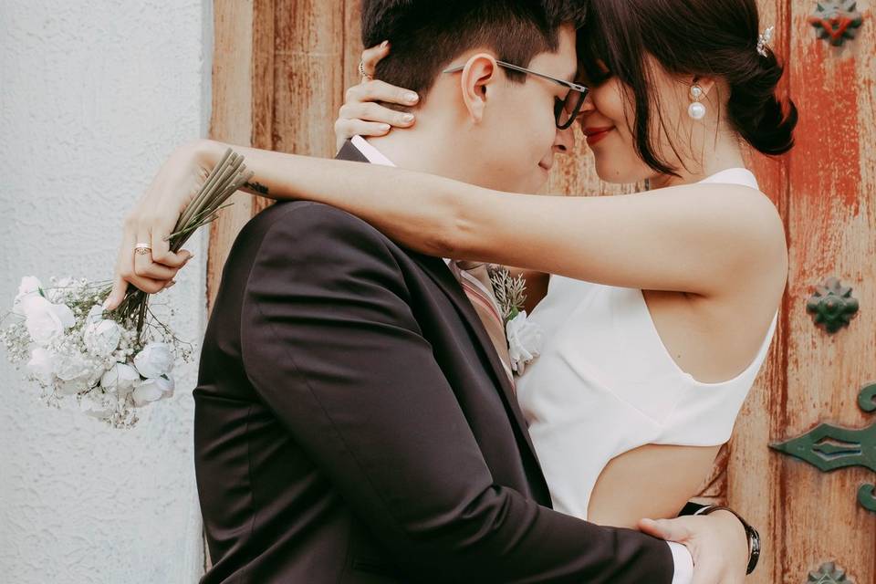 Novios abrazados frente a una puerta