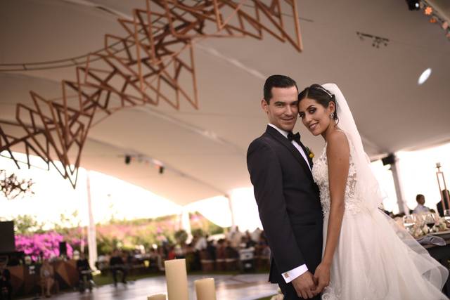 Pareja agarrada de la mano viendo a la cámara